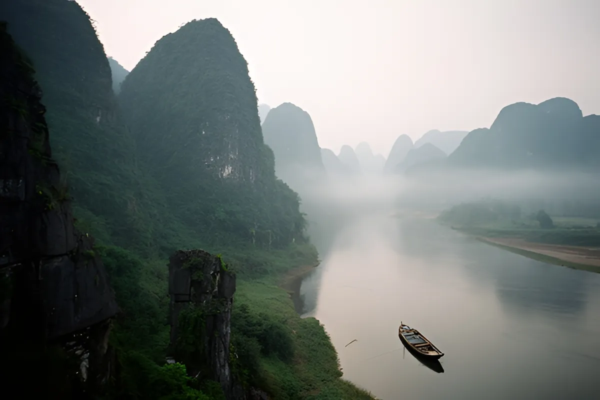 Thung lũng sông rộng yên tĩnh trong sương sớm, núi đá vôi xanh phủ kín một bên bờ